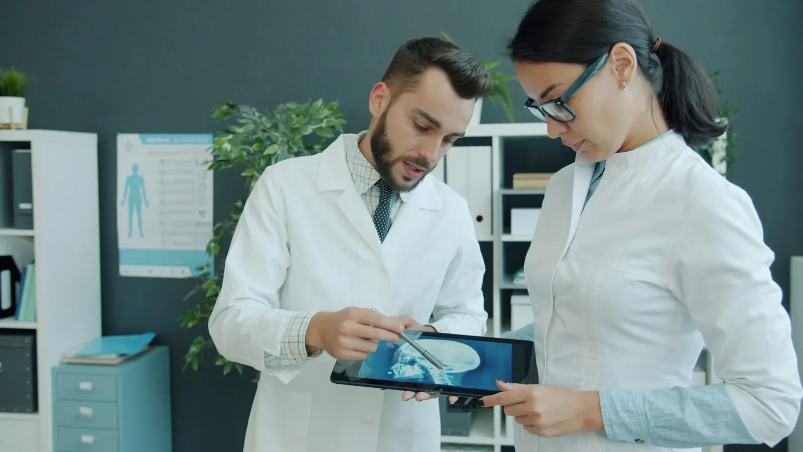Two doctors reviewing a medical scan together on a tablet