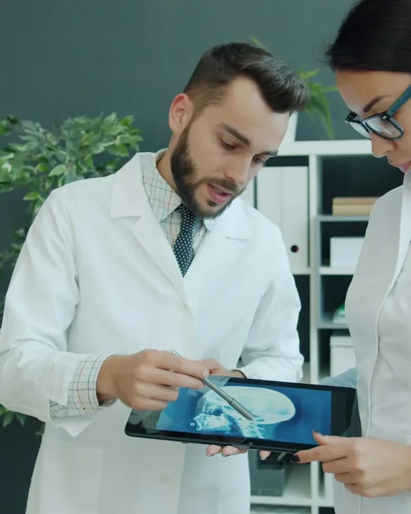 Two doctors reviewing a medical scan together on a tablet